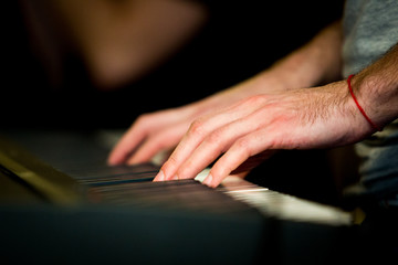 Close up male hands playing electric piano