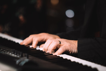 Close up male hands playing electric piano