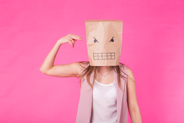 Concept of negative emotions - Angry woman with a paper bag on his face.