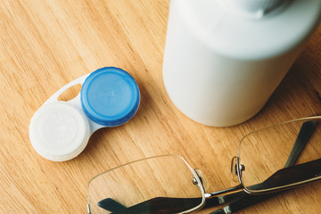 Contact lenses in containers, liquid in bottle for eye care and glasses, top view