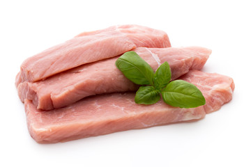 Fresh pork fillet with basil on a white background.