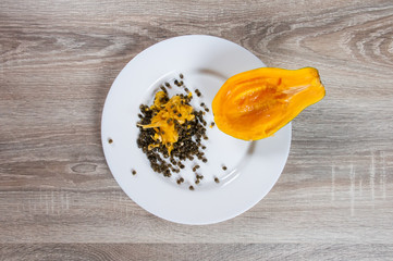 pieces of papaya in white plate on white background