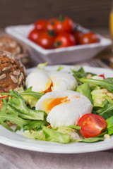 Poached egg with green salad, tomatoes, wholemeal bread and orange juice