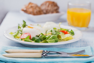 Poached egg with green salad, tomatoes, wholemeal bread and orange juice