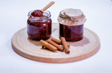 Homemade strawberry jam in jar and in wooden spoon