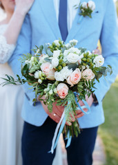 Bouquet in the hands of the groom, wedding day