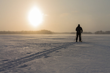 Off track cross-country skier on a windy frozen lake