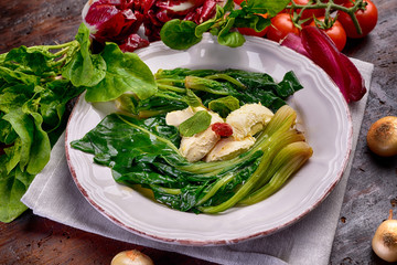 Round dish with buttered spinach on antique table