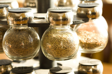 Three spices in small glass jars on a rack