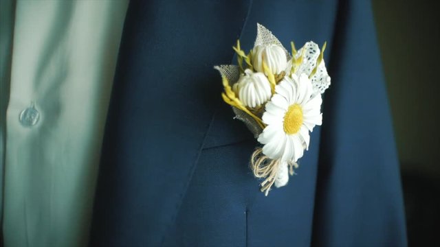 Groom adjusts wedding boutonniere. Clip. Groom boutonniere on a man corrects his pocket hand
