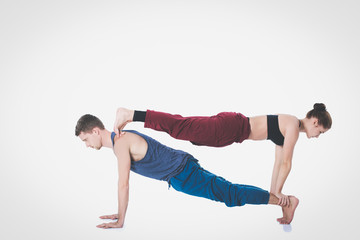 Naklejka premium Young athletic couple practicing acroyoga. Balancing in pair