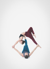Young athletic couple practicing acroyoga. Balancing in pair