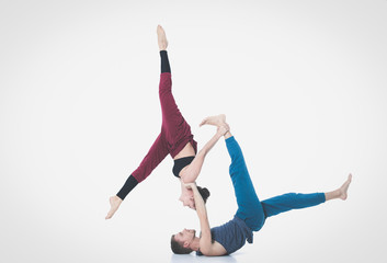 Young athletic couple practicing acroyoga. Balancing in pair
