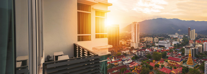Condominium balcony with sunset flare view from skyscraper building - Penang, Malaysia.