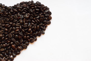 Roasted coffee beans in half heart shape on white background, isolated picture