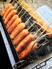 Thai sausage in Thai called Sai Krok Isan, made from mince pork, sticky rice, vermicelli. Mix all together, stuffed in pork chitterlings grilled on charcoal stove. Thailand street food.