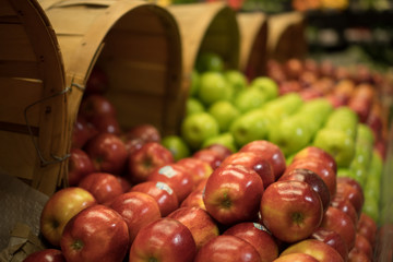 closeup of various apples in a basket at a market