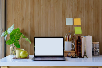 Mockup modern home decor blank screen laptop computer with office supplies and houseplant. Artist workspace white screen for graphic display montage.