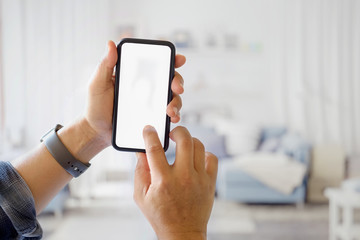 Cropped shot of man hand holding blank screen smartphone in living room.