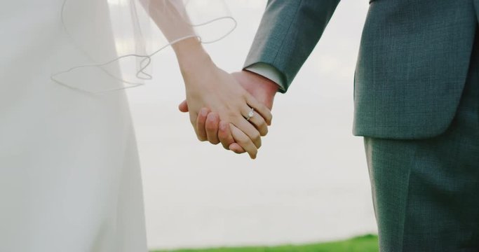 Bride and groom holding hands on wedding day