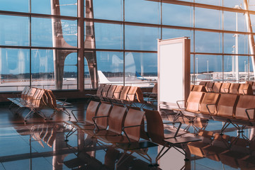 Empty white advertising banner template indoors of departure hall of airport terminal; blank...