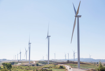 Rows of white wind turbines generating electricity in wind power station alternative renewable energy from nature on mountain © Soonthorn