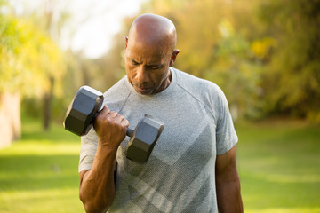 Fit African American man lifting weights