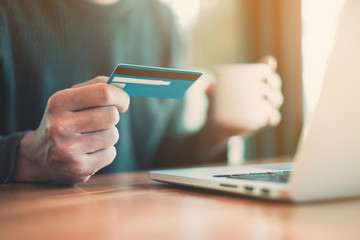 Asian man enjoy shopping with online shopping application and pay by credit card. Online payment concept.