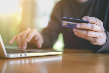 Asian man enjoy shopping with online shopping application and pay by credit card. Online payment concept.