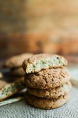 fresh homemade oatmeal cookies on wooden background with spikes of oats