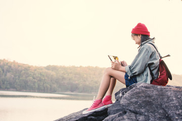 Asian girl playing tablet in nature , Relax time on holiday concept travel,selective and soft focus,tone of hipster style