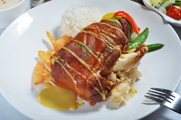 German BBQ pork knuckle and rice on white plate 