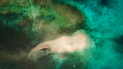 Aerial view of beautiful sand tropical island with white sand beach and tourists. White sand island. Seascape: ocean and beautiful beach paradise. Philippines, Siargao. Travel concept.