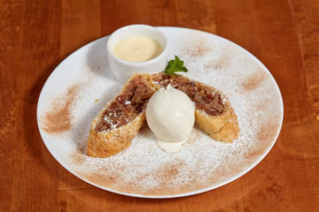 Apple strudel with ice cream scoop on plate