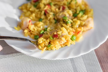 paella on a fork on white plate background