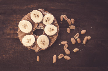Sweet bagel with peanut butter and banana slices. Tasty breakfast.