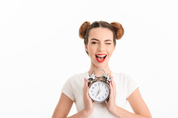 Portrait of a cheerful casual girl holding alarm clock