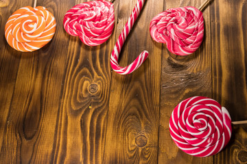 Sweet lollipops on rustic wooden background. Top view