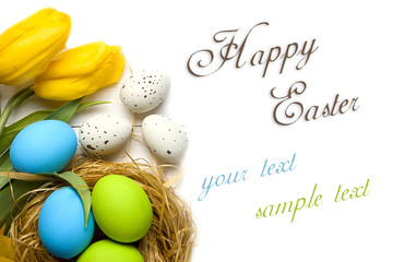 Easter card with colorful eggs in nest and yellow tulips over white background. Top view with copy space