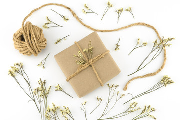 Fototapeta na wymiar Brown gift boxes and rope with yellow limonium caspia flowers on white wood background 