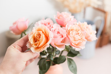 hand touches. Bouquet flowers of pink roses in glass vase. Shabby chic home decor. florist at a flower shop.
