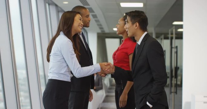 4K Smiling corporate business teams greet each other & shake hands in modern city office. Slow motion