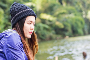 Asian woman wearing a knit cap traveling on holiday alone