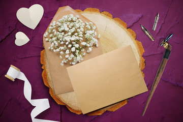 Calligraphic feather, lies near a wooden circle with a white paper heart. greeting card for Valentines Day with place for your text. Flat lay, top view photo mock up