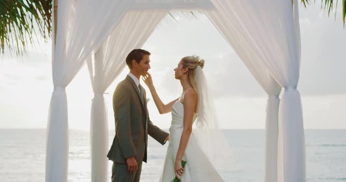 Bride and groom kissing on wedding day at sunset