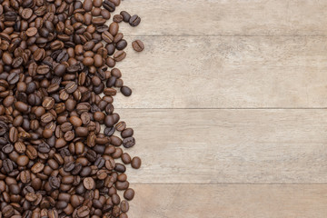 Top view of Coffee beans on a wooden table and was poured out. Helps skin smooth and clear. It also makes the blood circulation. Drink concept. Copy space.