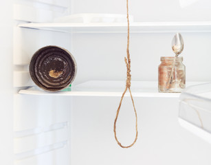 The refrigerator is empty. Dirty shelves. A spoon in the jar with the remains of food on it is not washed. The can is old not washed and rusty. in the center of attention is the rope and the loop on i
