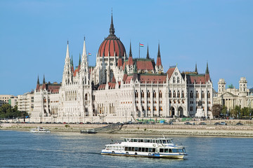 Fototapeta premium The Hungarian Parliament Building and sightseeing ships on the Danube in Budapest, Hungary