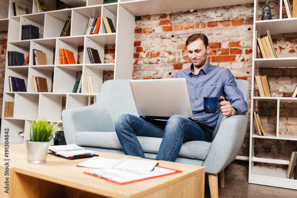 Wall mural Young man with a laptop