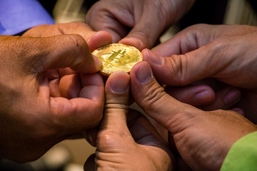 Many hand holding golden bitcoin coin. It is show symbol of unity and business related. money electronic for web banking 